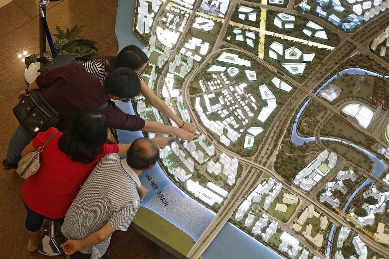 People viewing models of housing projects on sale, at the HDB Hub yesterday. From yesterday, the income ceiling for Singaporean households to buy new flats and ECs was raised by $2,000, to $12,000 and $14,000 respectively.