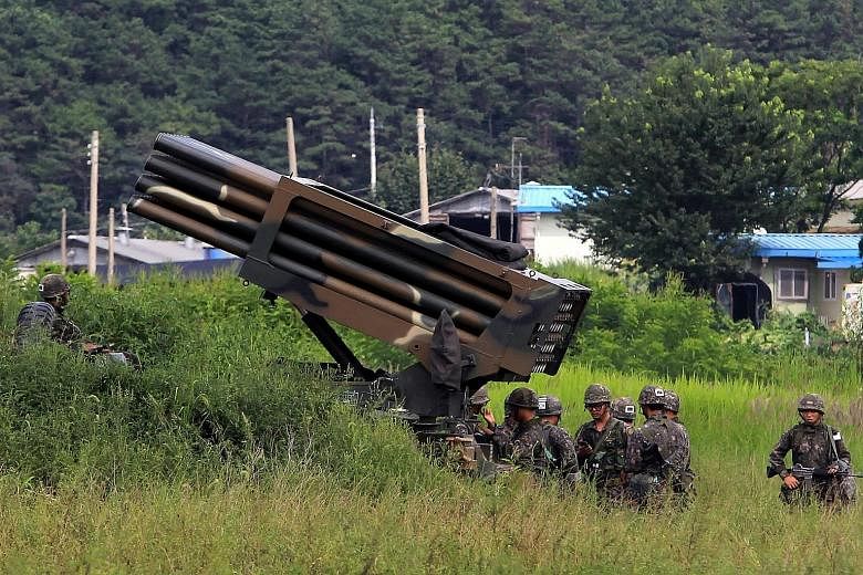 South Korean soldiers setting up a multiple launch rocket system yesterday in Yeoncheon. Despite the military activity, civilian life in the South remains unchanged, with many immune to the North's recurring threats.