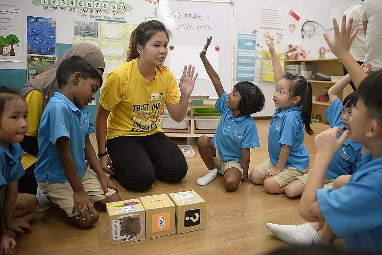 Ngee Ann Polytechnic Child Psychology and Early Education student Eden Yeong, 19, playing a game of word dice with children at the MOE Kindergarten at Dazhong Primary.
