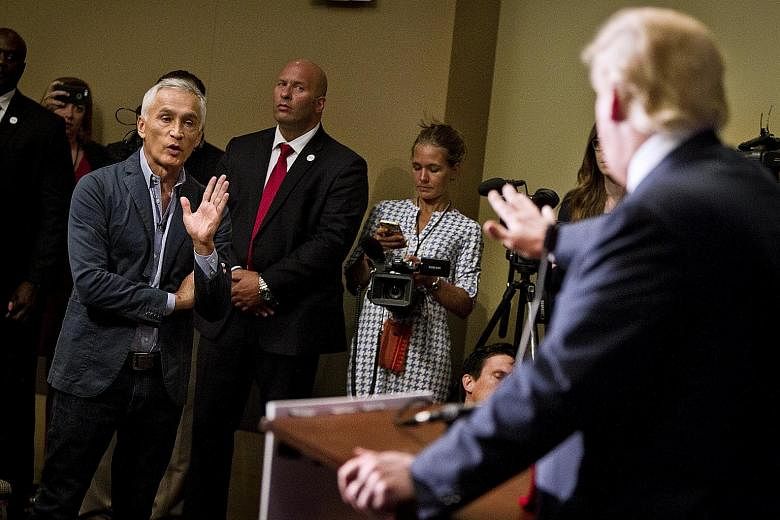 Republican presidential hopeful Donald Trump (right) sparring with Univision reporter Jorge Ramos during a Tuesday press conference.