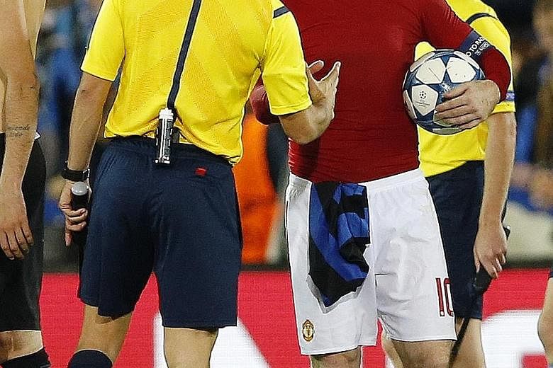 Delighted Manchester United captain Wayne Rooney, armed with the match ball, shakes hands with referee Antonio Mateu Lahoz.