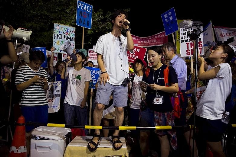 Mr Aki Okuda (with microphone), founding member of the protest group Students Emergency Action for Liberal Democracy, leading a protest outside Parliament in Tokyo last week. Japan has not seen significant student protests since the 1960s and the gro