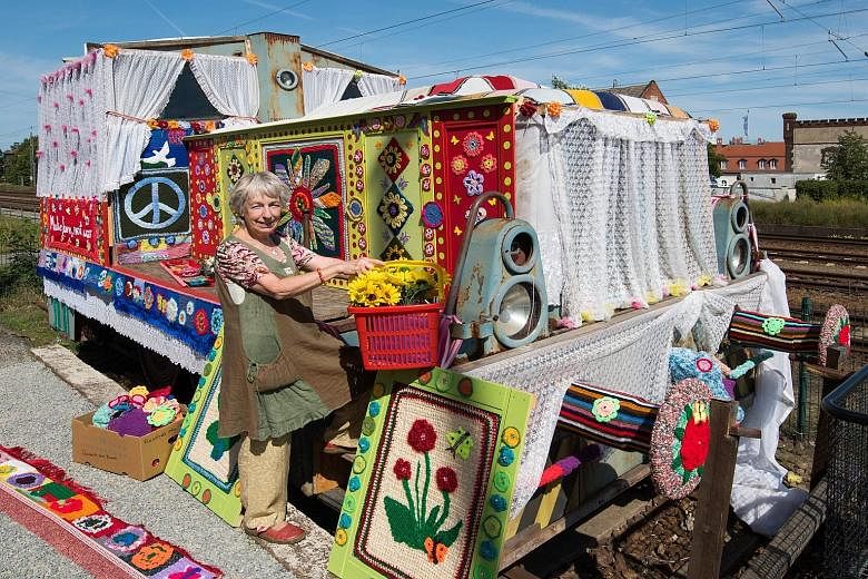 German peace activist Christa Senberg posing with an old diesel locomotive covered with knitted works in Zossen, Germany. The movement, "Knitting for Peace", which was co-initiated by Ms Senberg, is being held for the second time after its success in