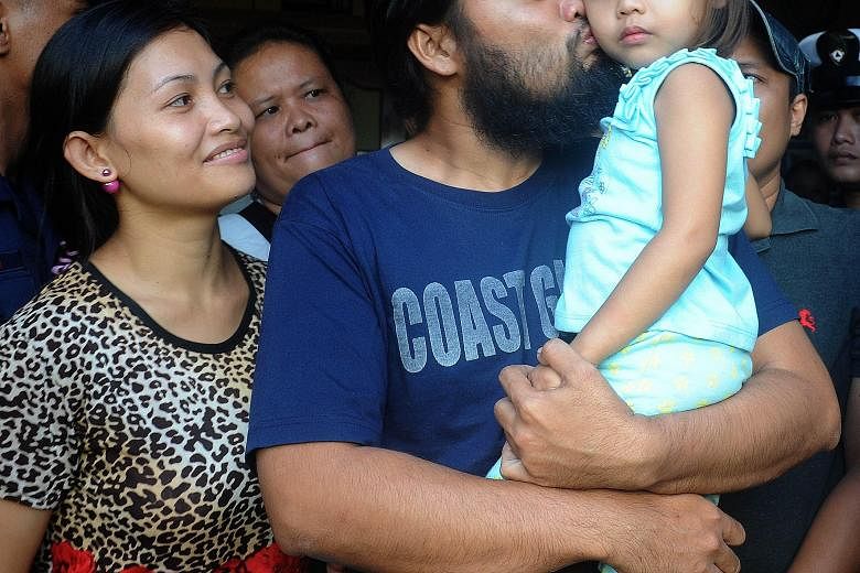 Philippine Coast Guard officer Rod Pagaling, one of the two hostages who escaped after elite military forces launched a risky rescue effort last week, with his wife and daughter.