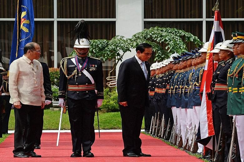 Mr Prayut Chan-o-cha reviewing the guard of honour during a welcoming ceremony in the Malacanang Palace grounds in Manila yesterday as Philippine President Benigno Aquino looked on.