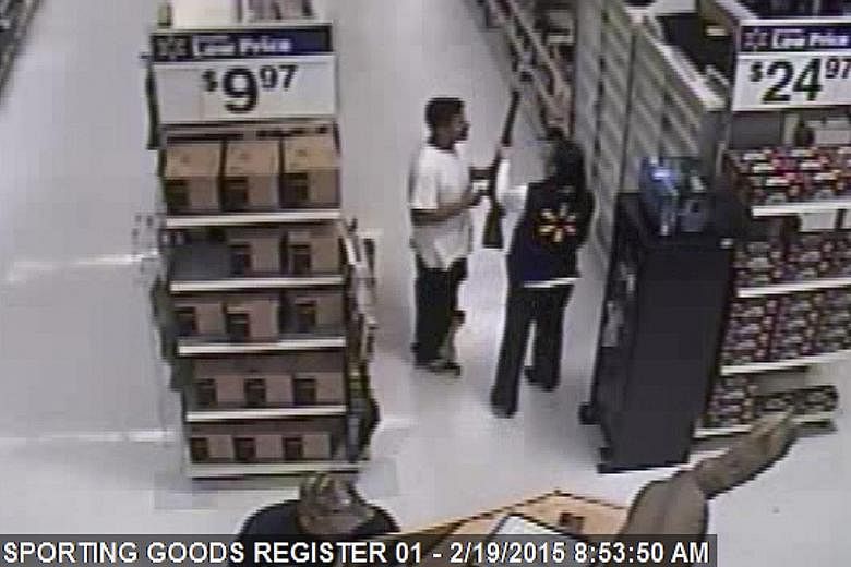 A video grab from a Walmart store shows Mario Valencia holding a rifle as an employee reaches for it in the Walmart store in Arizona on Feb 19. He would later go on to be charged with robbing a convenience store, breaking into a church, invading a ho