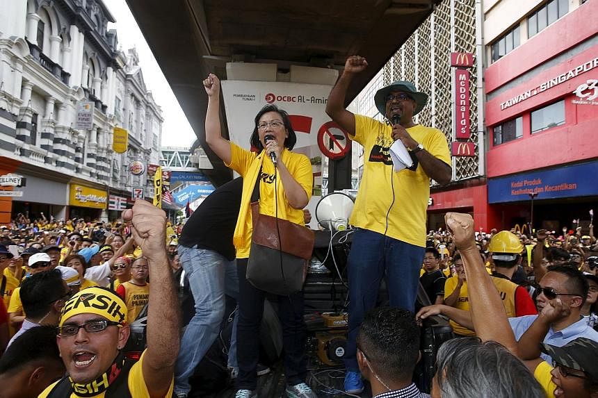 Clockwise from right: Malaysia's ex-PM Mahathir Mohamad and his wife Siti Hasmah dropped in on the Bersih event yesterday; the group's chairman Maria Chin Abdullah rallying the supporters; Wan Azizah (in sunglasses), the wife of jailed opposition lea