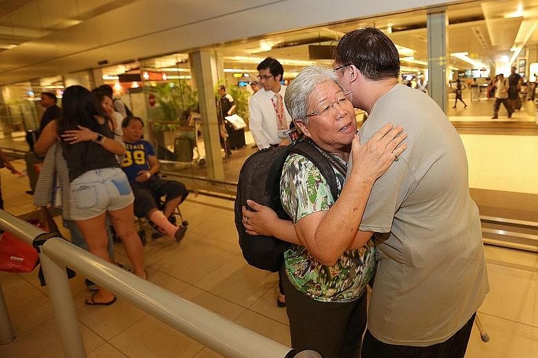 Ms Betty Ong, who was hurt in the bomb attack at the Erawan Shrine on Aug 17, receiving a hug from a relative at the airport last night.