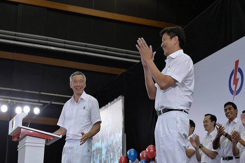 Above: Party members applauding yesterday after PM Lee introduced all the new PAP candidates. Right: PM Lee introducing former defence force chief Ng Chee Meng as a new member of the PAP. Ms Tin Pei Ling, who gave birth just three weeks ago, said she