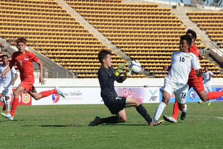 Singapore Under-19 goalkeeper Benedict Loh tries to get the ball ahead of Myanmar forward Aung Zin Phyo as Muhammad Shah (No. 5) looks on. Myanmar won 1-0.