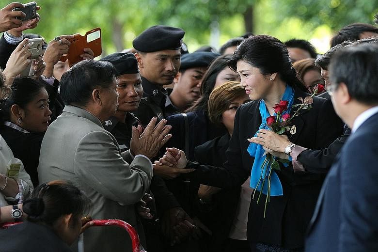 Ms Yingluck Shinawatra was handed roses by supporters as she arrived at the court yesterday for a case involving her rice subsidy scheme when she was Thailand's premier.