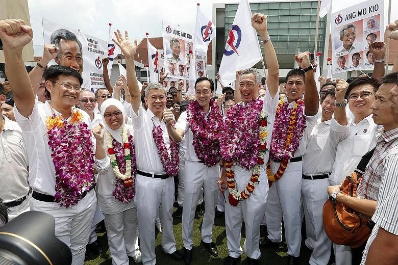 PAP candidates for Ang Mo Kio GRC (wearing garlands, from left) Mr Gan Thiam Poh, Dr Intan Azura Mokhtar, Mr Ang Hin Kee, Dr Koh Poh Koon, PM Lee Hsien Loong, and Mr Darryl David.