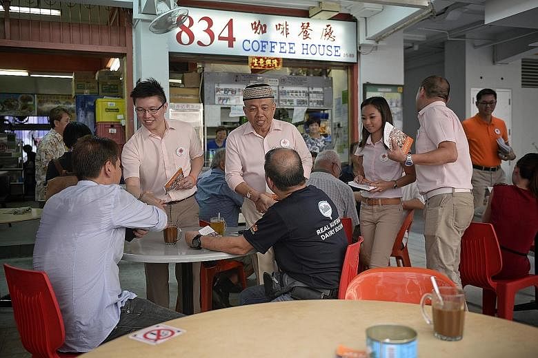 NSP candidates for Sembawang GRC (from left) Spencer Ng, Yadzeth Haris, Kevryn Lim and Eugene Yeo meeting residents at a coffee shop at Block 834, Woodlands Street 83, yesterday.