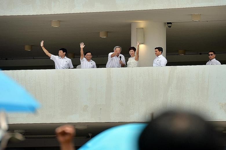 Dr Ng Eng Hen (third from left) with his fellow PAP candidates (from left) Chee Hong Tat, Chong Kee Hiong, Josephine Teo and Saktiandi Supaat at the Raffles Institution nomination centre yesterday. Workers' Party backers were also at Poi Ching School