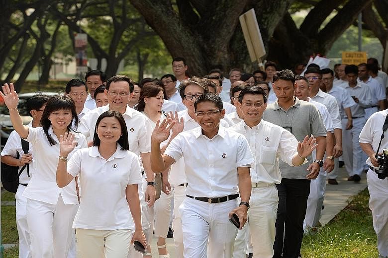(Front row) PAP's Ms Cheryl Chan and Mr Maliki Osman, (second row, from left) Ms Jessica Tan, Mr Raymond Lim, Mr Lim Swee Say and Mr Lee Yi Shyan, and their supporters arriving at Fengshan Primary School.