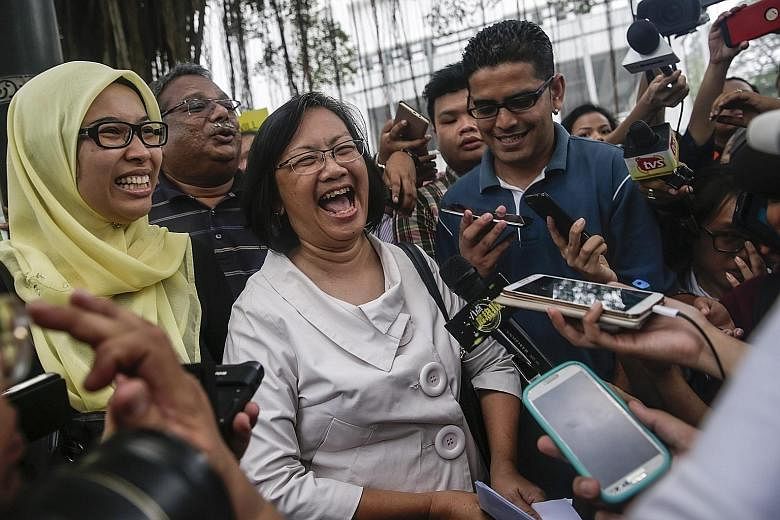 Malaysian police said they want to know where Dr Mahathir Mohamad (left) got his information. Bersih chairman Maria Chin Abdullah (in white) speaking to the media in front of the police headquarters in Kuala Lumpur yesterday. Seven organisers of the 