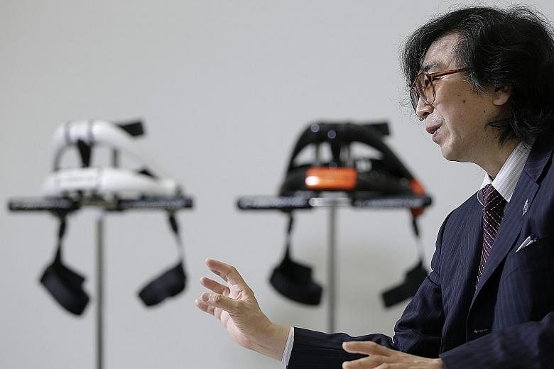 Scientist Yoshiyuki Sankai, pictured with his robot exoskeletons, wants to treat spinal injury patients by using stem cell-related technology to repair nerve connections and robotic suits that aid movement.