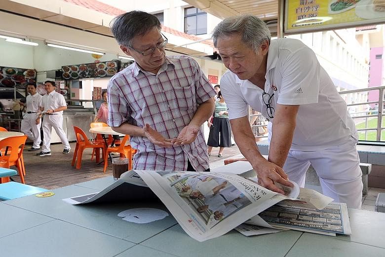 Defence Minister Ng Eng Hen reading the newspapers yesterday at a coffee shop while on a walkabout in Bishan-Toa Payoh GRC. Dr Ng said that while some of the feedback of opposition MPs is important, that of the PAP MPs is critical. He noted that PAP 