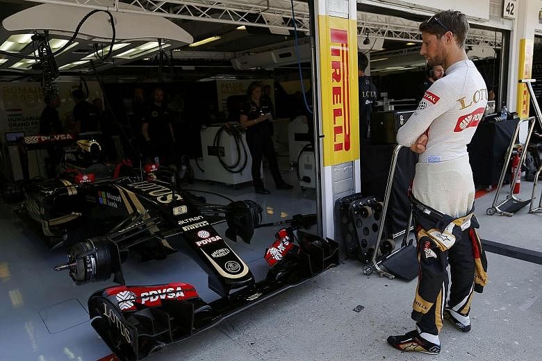 Lotus Formula One driver Romain Grosjean of France in the team garage during the Hungarian Grand Prix weekend. While the team had experienced difficulty in paying for their tyres, Grosjean finished third at the Hungaroring circuit to provide a huge m