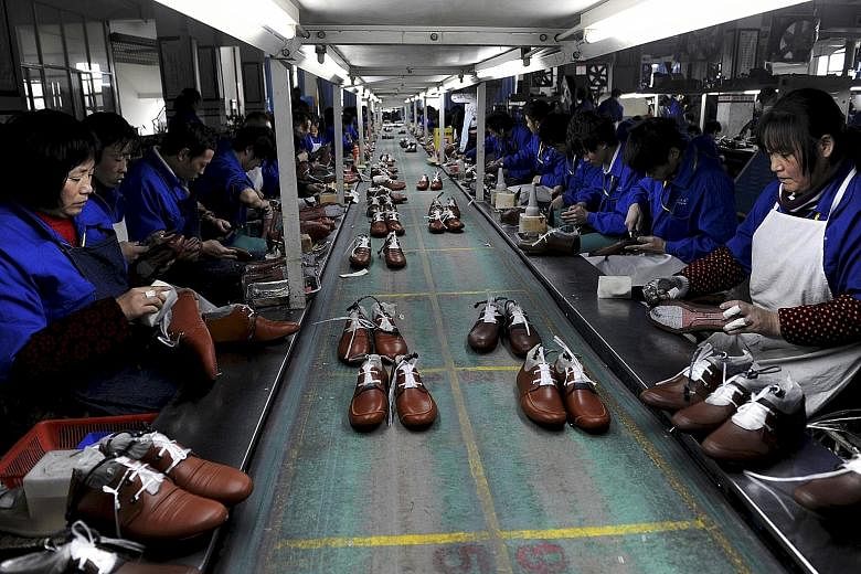 Employees at a shoe factory in Lishui, Zhejiang province, in this Jan 24, 2013 file photo. China's manufacturing PMI fell from 50 in July to 49.7 last month, its lowest level in three years. The dismal data sent global stock markets into a tailspin,