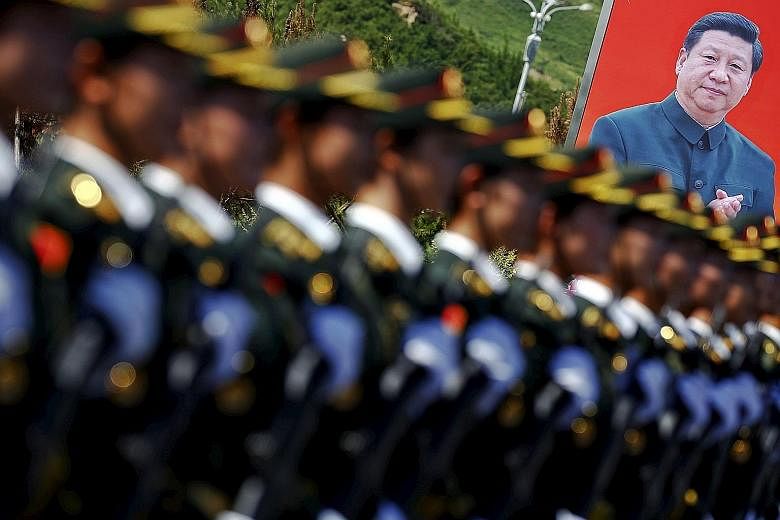 Soldiers of the People's Liberation Army marching in front of a poster of Chinese President Xi Jinping during a training session in August. Mr Xi on Thursday announced the unexpected reduction of 300,000 troops, which is said to be part of broader re