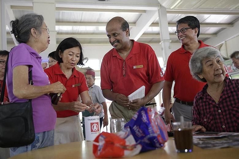 Prof Paul Tambyah (centre) chats with residents at the Empress Road food centre as Mr Sidek Mallek looks on. Both men are Singapore Democratic Party candidates for Holland-Bukit Timah GRC.