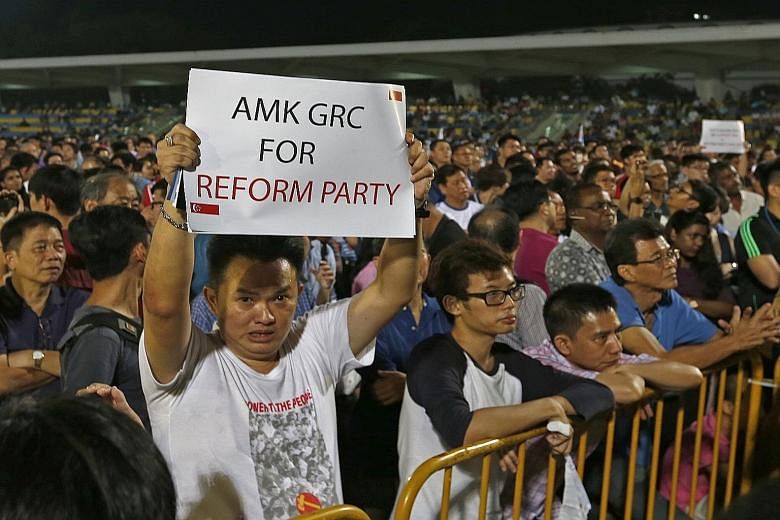 A Reform Party supporter holding up a card during the party's rally at Yio Chu Kang Stadium yesterday.