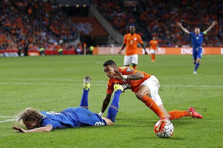 Netherlands defender Gregory van der Wiel (right) giving away a penalty for this foul on Iceland's Birkir Bjarnason, which drew stinging criticism from his coach.
