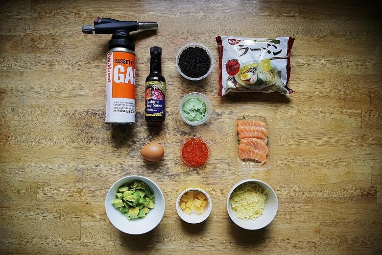 From top row: blow-torch, sashimi soya sauce, lumpfish caviar, instant ramen, wasabi, egg, salmon roe, salmon sashimi, avocado, tamago and grated cheese. Mr Jonathan Loong plans to make a chicken rice version of the ramen pizza as a tribute to his Ha
