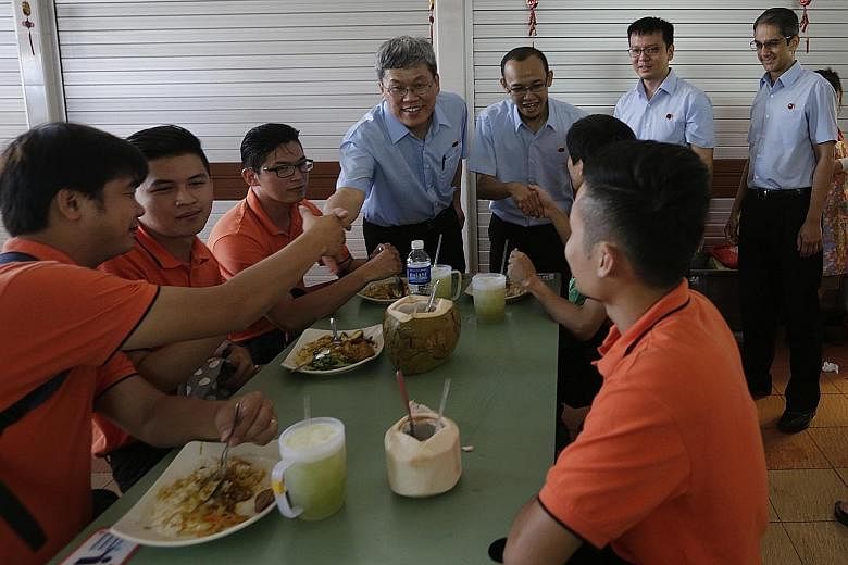 Mr Png Eng Huat (centre) with Workers' Party candidates for East Coast GRC (from left) Fairoz Shariff, Daniel Goh and Leon Perera at their walkabout in Changi Village yesterday.