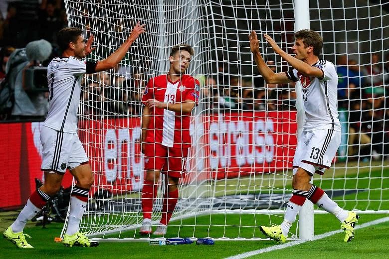 Thomas Mueller (right) celebrates with Jonas Hector after he opens the scoring for Germany in the first half of their 3-1 Euro 2016 qualification win over Poland in Frankfurt.