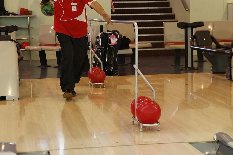 Thomas Yong, who is blind, bowls with the help of a guide rail.