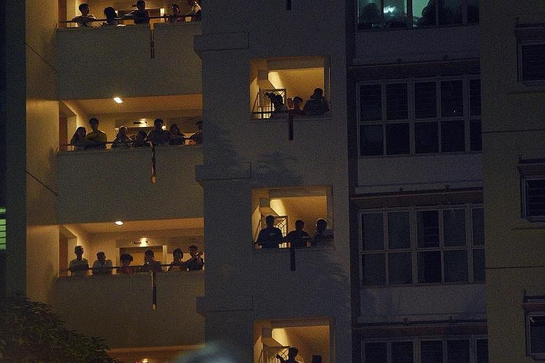 People at a nearby HDB block watching Workers' Party candidate Chen Show Mao speaking at last night's rally at Punggol Field. WP's Ms Lee Li Lian will be contesting in Punggol East SMC.