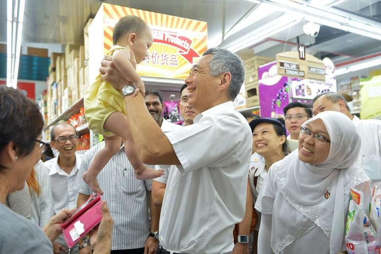 Prime Minister Lee Hsien Loong with Dr Intan Azura Mokhtar (right) during a visit to Sheng Siong supermarket in Serangoon North Avenue 4 last Thursday. Both candidates are part of the People's Action Party team that is contesting in Ang Mo Kio GRC. 