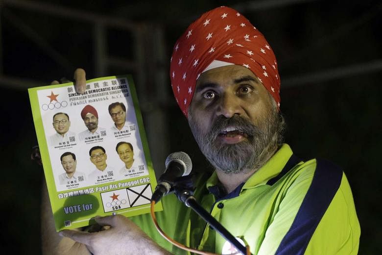 Mr Harminder Pal Singh holds up the Singapore Democratic Alliance pamphlet at a rally for Pasir Ris-Punggol GRC in Pasir Ris Park. 