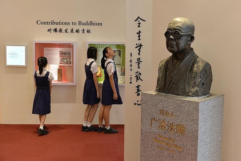 Pupils learning more about the school's contributions to Singapore's Buddhist culture and traditions at the new heritage centre, where a bronze sculpture of Mee Toh's founder, Venerable Kong Hiap, stands guard. 