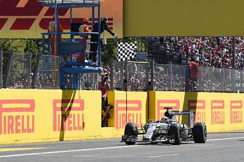 Lewis Hamilton crosses the finish line ahead of Ferrari's Sebastian Vettel to win the Italian Formula One Grand Prix at the Autodromo Nazionale circuit in Monza yesterday.