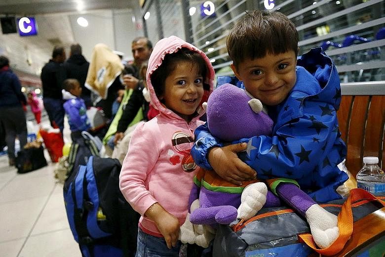 Two Syrian children sharing a stuffed toy given to them by wellwishers after they arrived by train from Budapest, Hungary, at Frankfurt airport's railway station in Germany early yesterday morning.