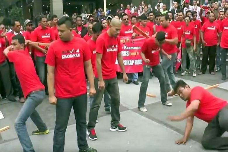 A red-shirted group put on a "self-defence" display just days before Bersih's rally on Aug 29-30. Members broke wood and roof tiles on one another's backs and heads, in what was seen as a warning to supporters of the Bersih rally.