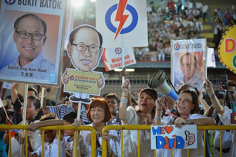 Mr David Ong's supporters holding up placards and signs at the PAP rally at Jurong East Stadium last night.