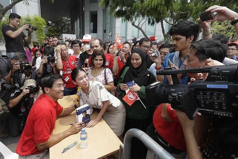 Dr Chee Soon Juan taking pictures with members of the public during a book signing session after yesterday's rally.
