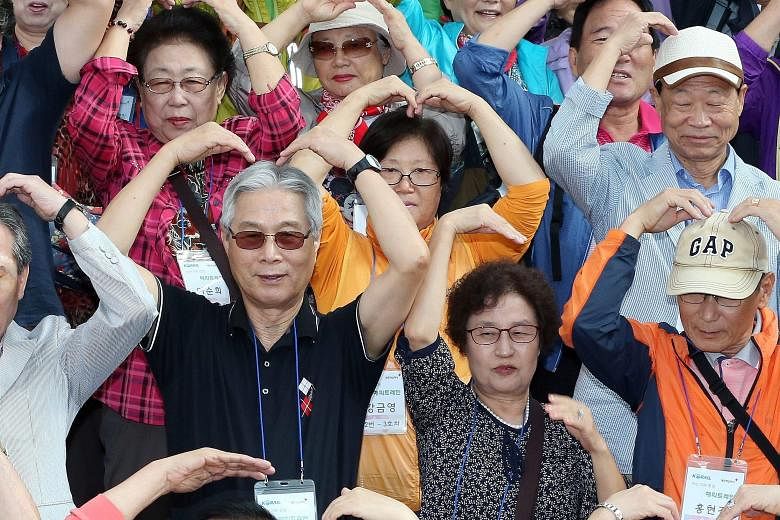 A group of South Koreans, separated from their kin in North Korea, making heart shapes at Seoul Station before they boarded a train bound for the South Korean border town of Cherwon yesterday. The excursion was co-organised by the Red Cross and the n