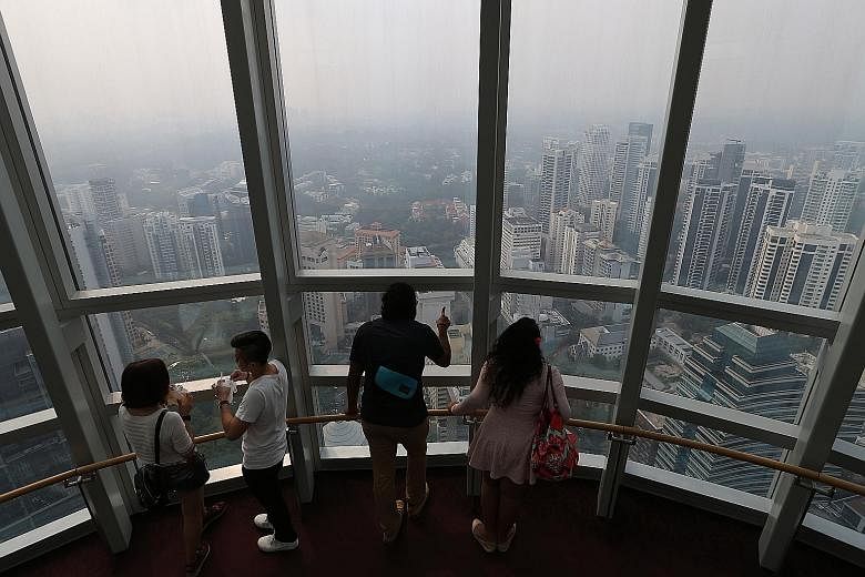 The Singapore skyline shrouded in haze at about 4.30pm yesterday, as seen from the Ion Sky observation deck. The hazy conditions are expected to persist due to smoke haze from Sumatra, says the NEA.