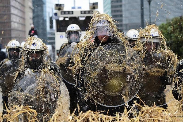 Thousands of angry European farmers pelted the police with eggs and hay in Brussels as they demanded emergency EU funds to help them cope with plunging food prices and soaring costs.