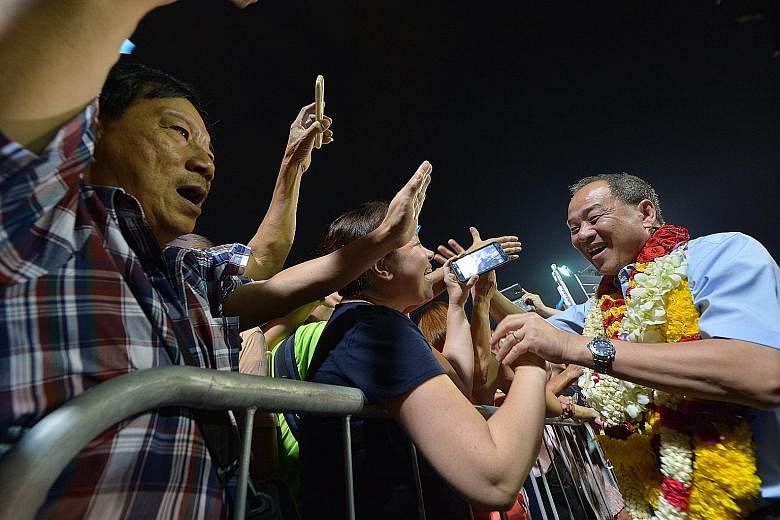 Workers' Party chief and Aljunied GRC candidate Low Thia Khiang greeting a supporter at the WP rally in Serangoon Stadium yesterday.