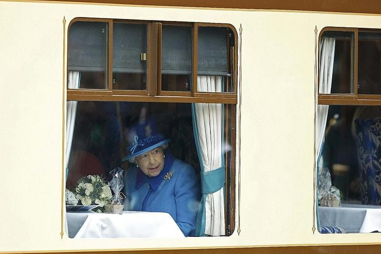Queen Elizabeth II on board a steam train at Edinburgh Waverley Station in Scotland yesterday. The monarch ascended the throne at the age of 25 when her father, King George VI, died on Feb 6, 1952.