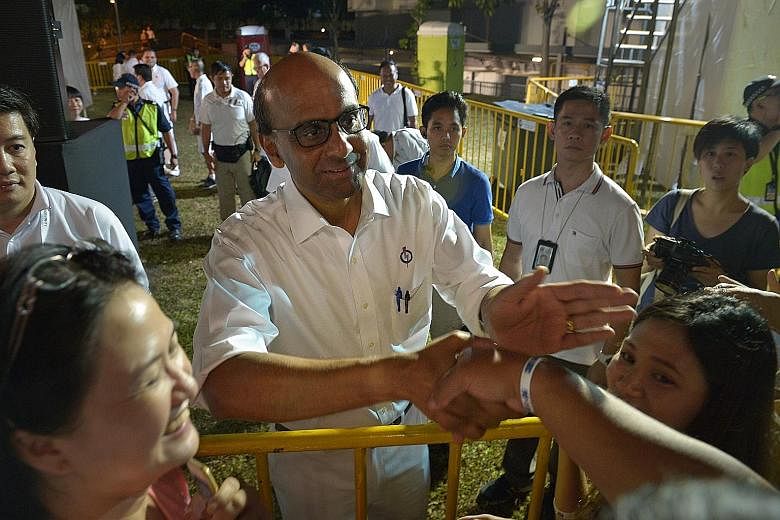 Mr Tharman greeting people at the PAP's East Coast GRC rally in Simei last night. He said that the Government does not spend the money it earns from selling land, but instead puts it into the reserves, adding that "this is simply prudent long-term bu