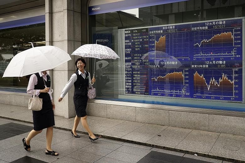 A stock market board in Tokyo, where shares soared 7.7 per cent yesterday. Stocks also rose in other Asian markets, including in Singapore where the STI gained 1.5 per cent.