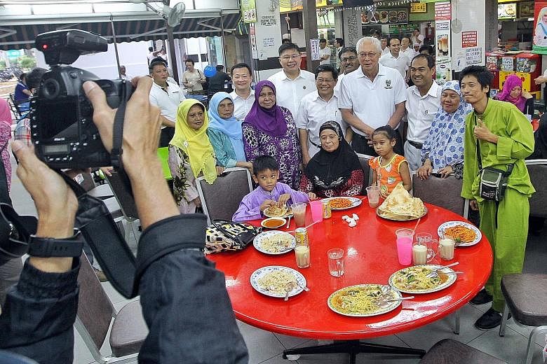 Emeritus Senior Minister Goh Chok Tong posing for a group photo with Malay diners during his visit to a halal coffee shop in Aljunied GRC yesterday, the last day of campaigning for GE2015.