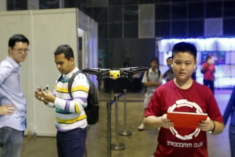 Tse Chung Man, 14, flying a mini-drone in the "Drone Zone" at the Infocomm Development Authority's Young Tech Fest. Other visitors were there to try out different technologies or take part in free workshops.